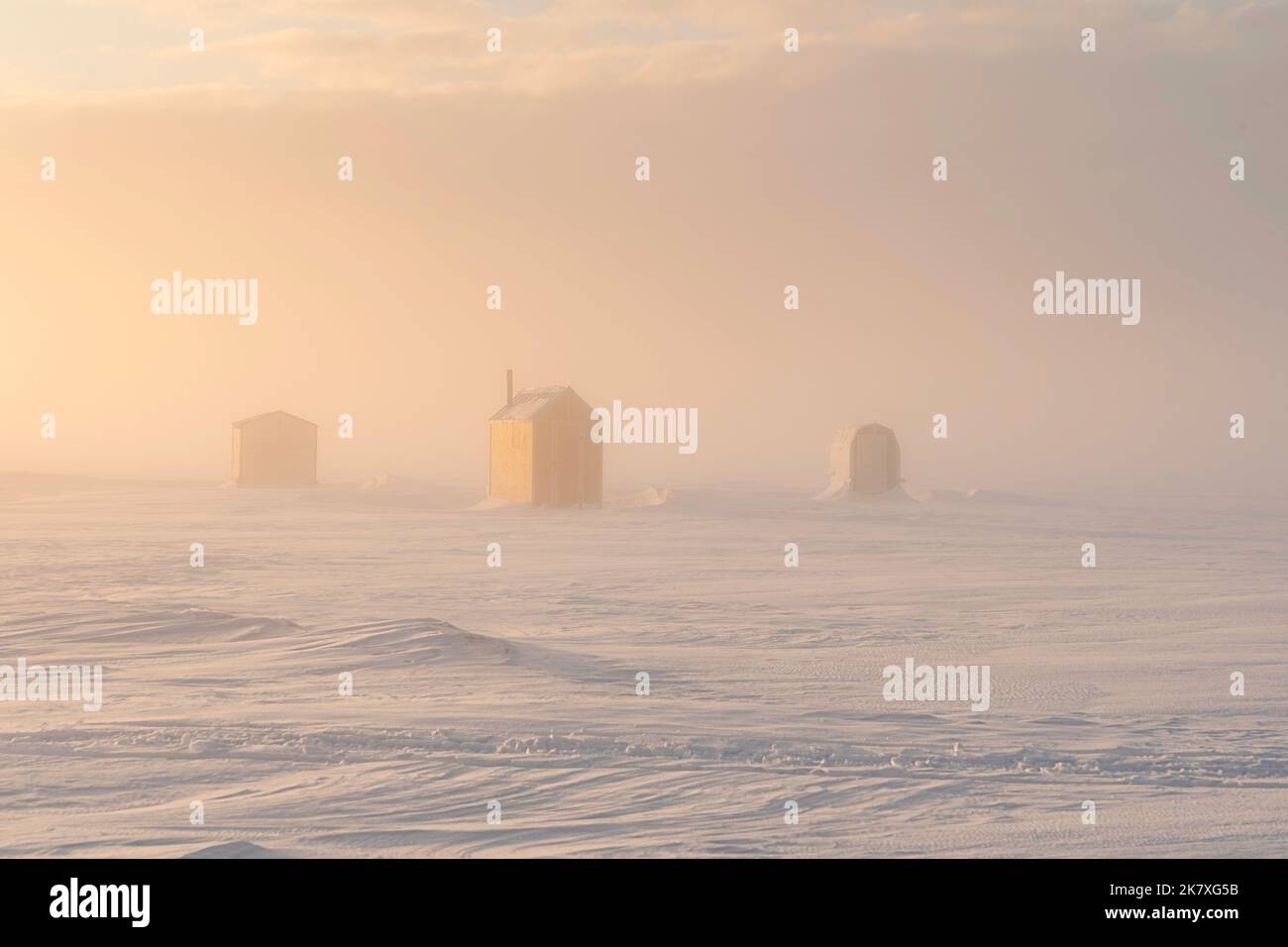 Pêche sur glace dans un port gelé dans la région rurale de l'Île-du-Prince-Édouard, Canada. Banque D'Images