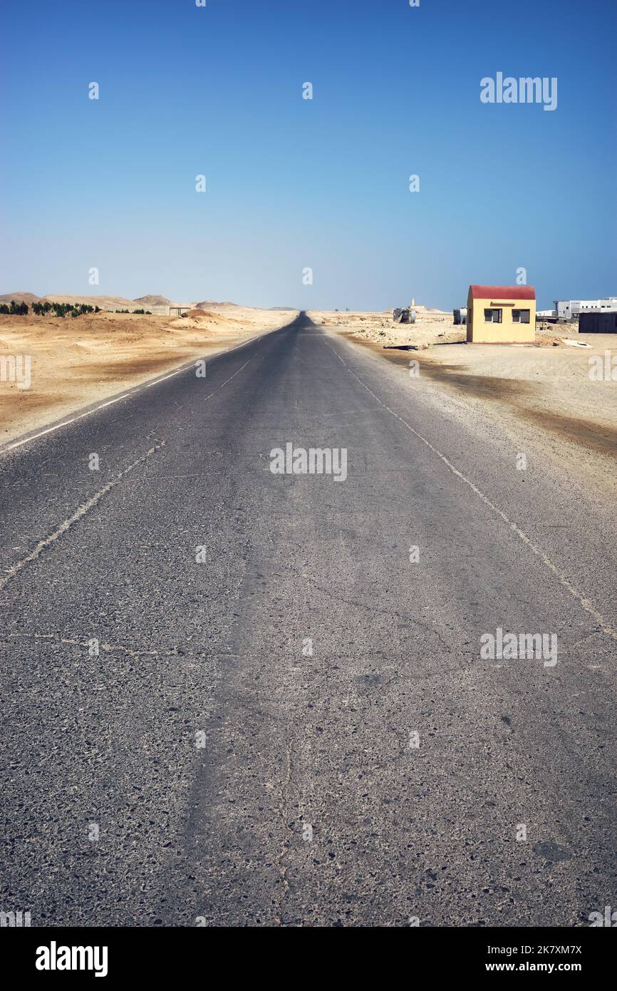 Route désertique asphaltée vide, mise au premier plan, virage de couleur appliqué, Egypte. Banque D'Images