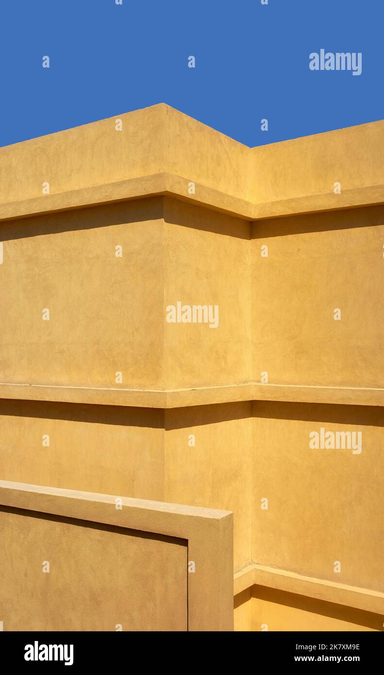 Mur de bâtiment jaune contre le ciel bleu. Banque D'Images