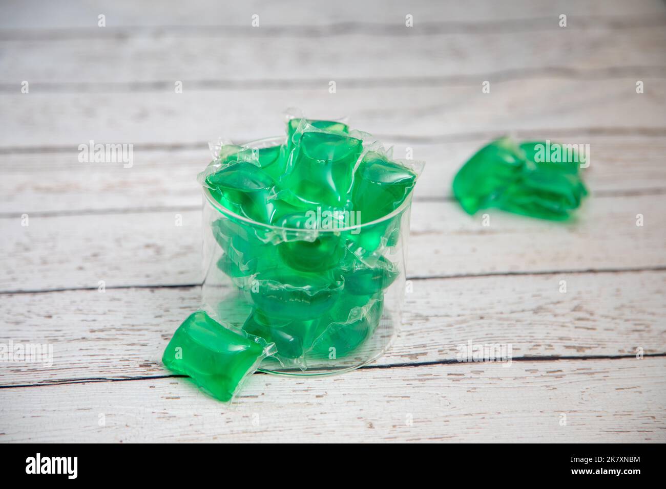 Tablettes de vaisselle dans un récipient en verre sur un comptoir en bois blanc Banque D'Images