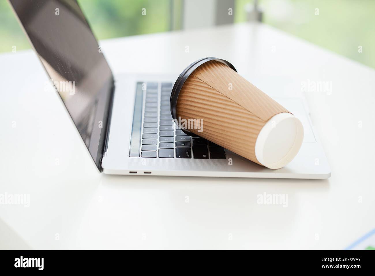 Versez du café sur le clavier de l'ordinateur portable à partir du verre de papier Banque D'Images Versez du café sur le clavier de l'ordinateur portable à partir du verre de papier Banque D'Images