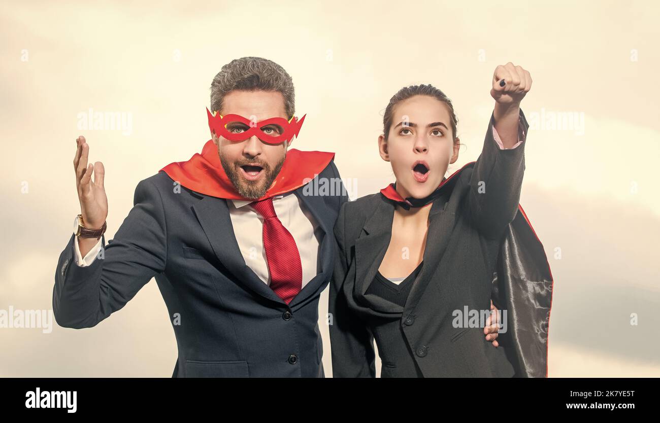 un couple d'affaires stupéfait dans un costume super-héros sur fond de ciel Banque D'Images