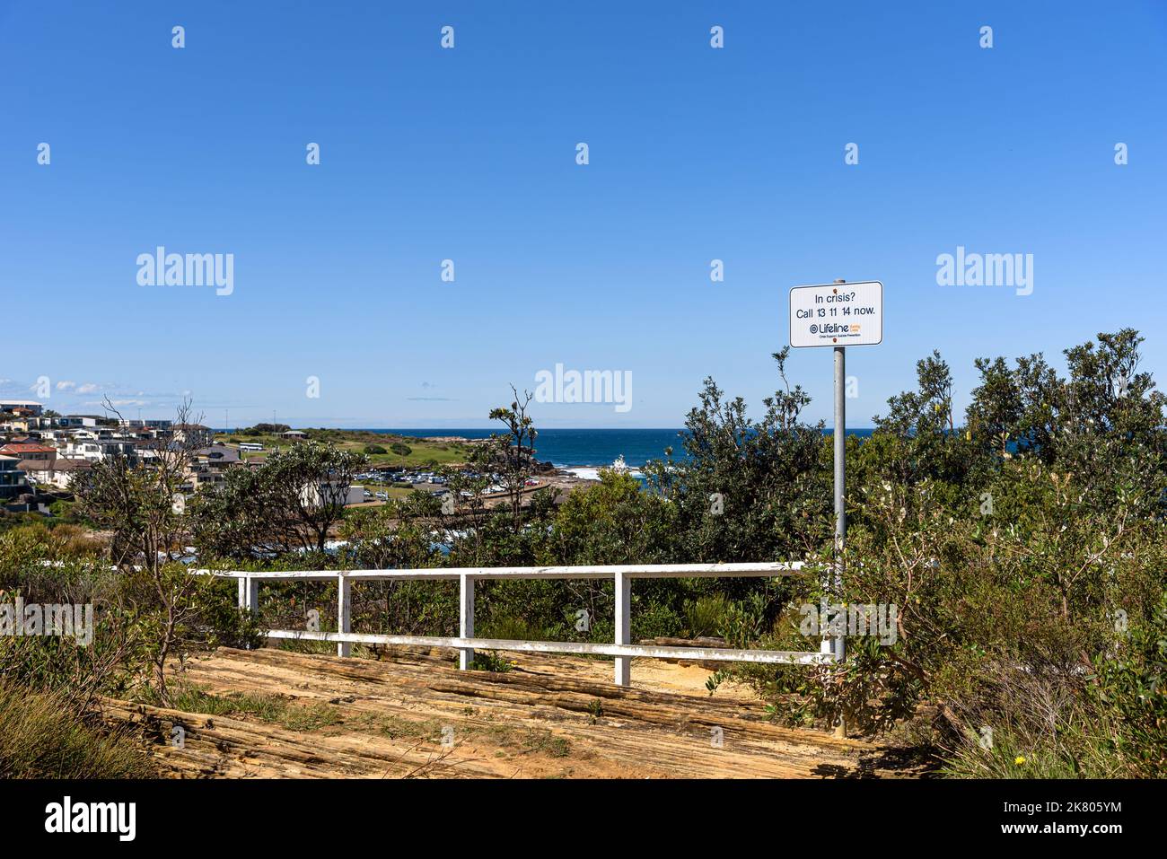 Un panneau pour une ligne d'assistance téléphonique de prévention du suicide aux falaises de la réserve de Dunningham le long de la promenade de Bondi à Coogee Banque D'Images