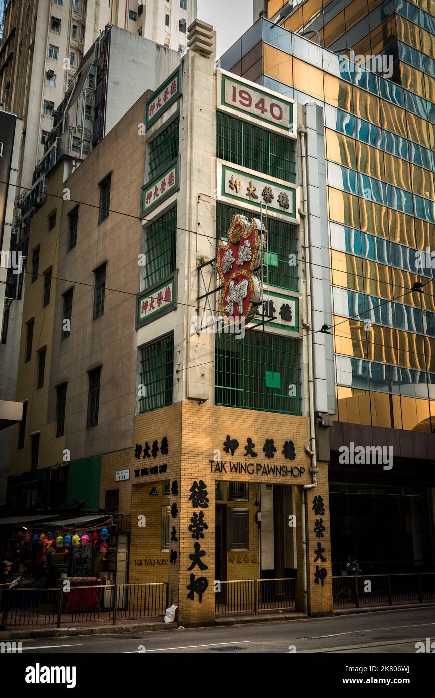 Le magasin de pawnshop Tak Wing, un magasin de pawn chinois traditionnel dans un magasin de 'Tong lau' à côté d'un immeuble de bureaux moderne de haute hauteur, Central, île de Hong Kong Banque D'Images
