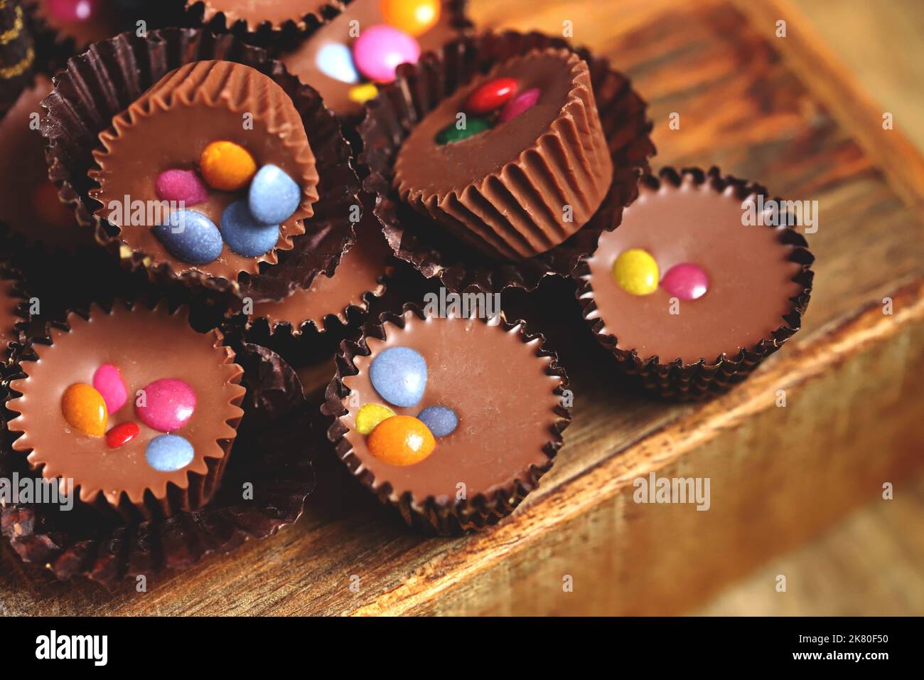 Mise au point sélective. Macro. Petites bonbons au chocolat sur une planche en bois. Banque D'Images