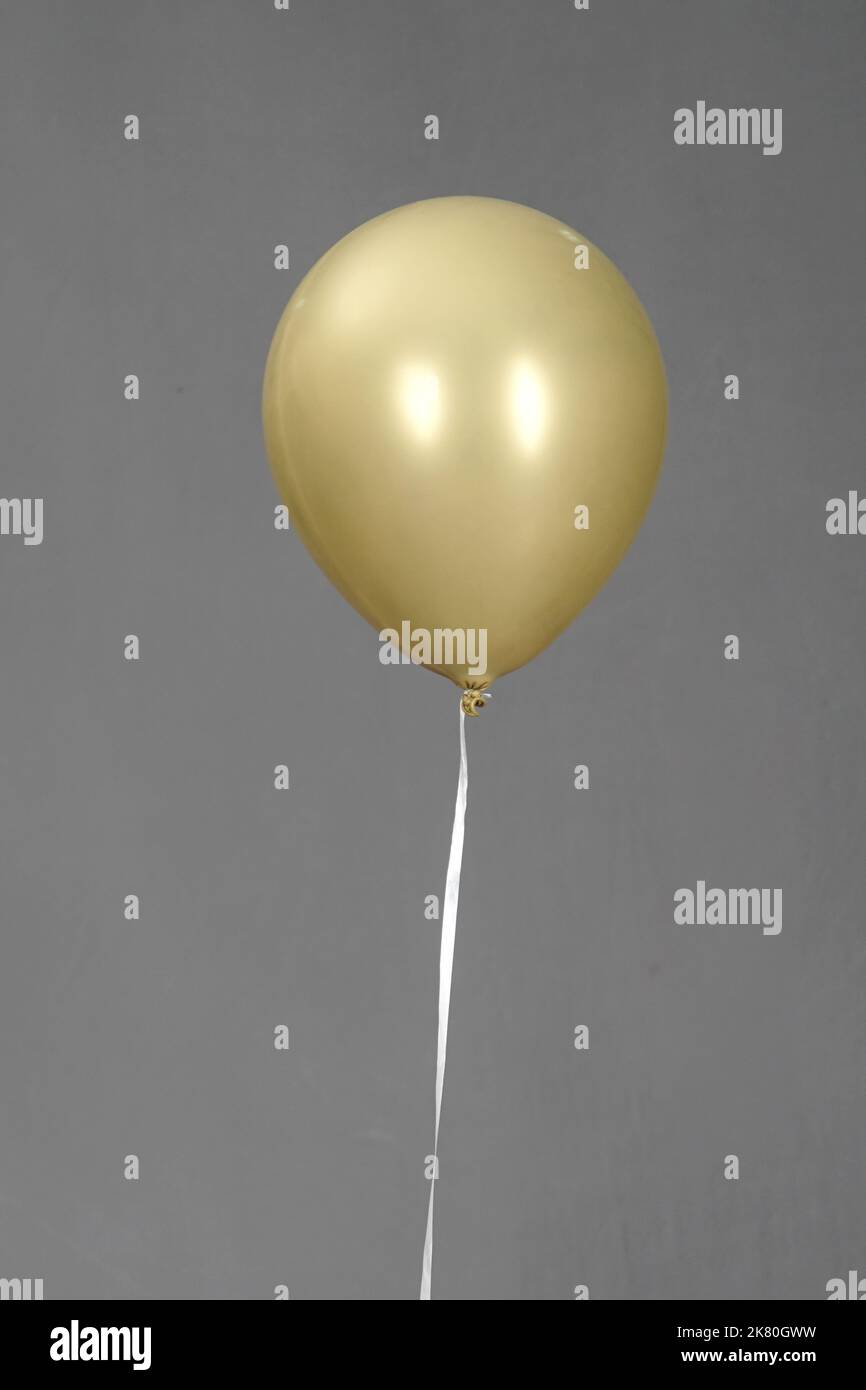 ballon de couleur or isolé dans un fond gris ballon de couleur or isolé dans un fond gris Banque D'Images