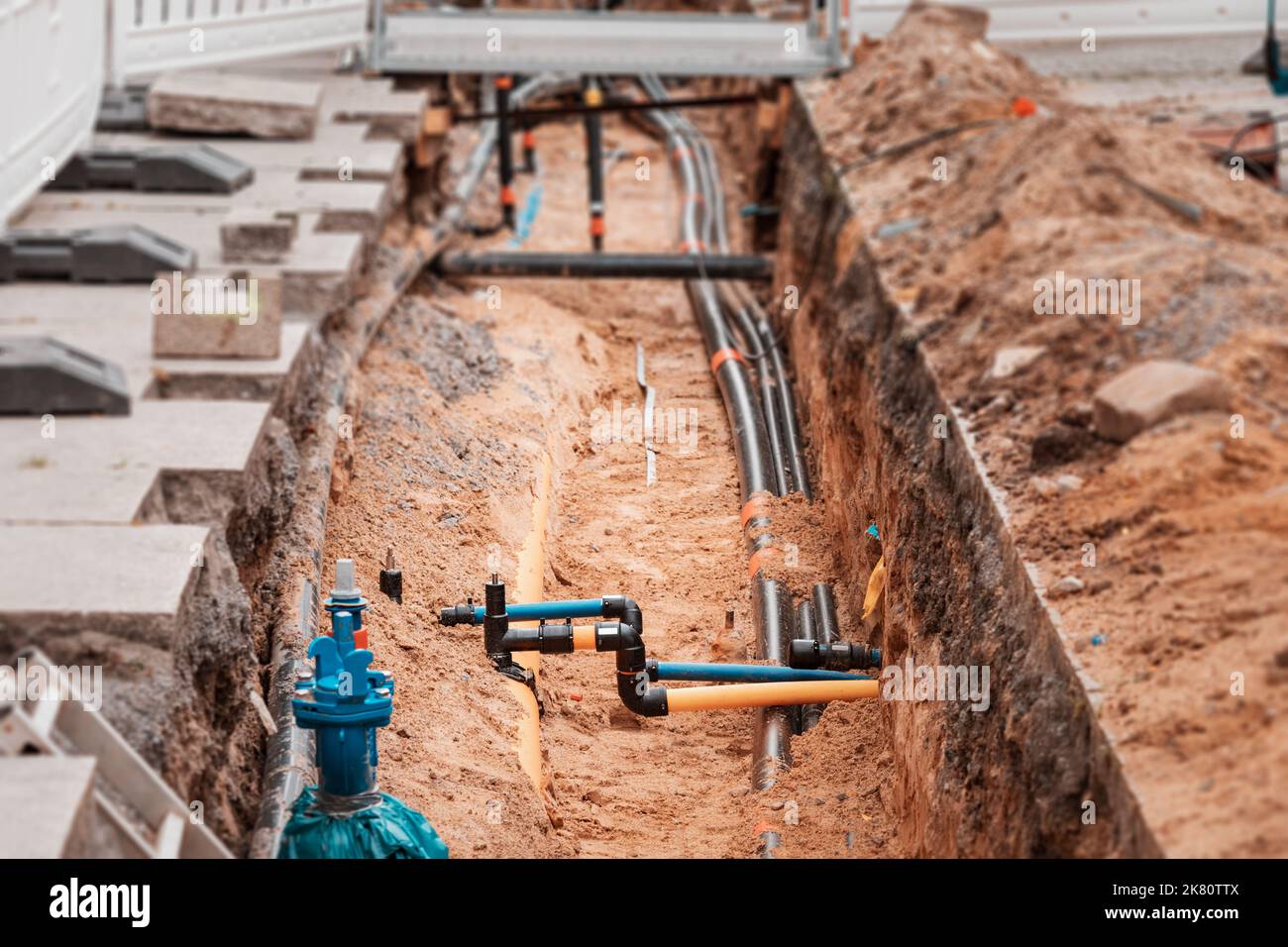 Tranchée d'excavation sur une rue de ville pour remplacer les tuyaux d'eau en plastique ou les câbles de pose. Réparation et rénovation sur le site de construction et de développement. Banque D'Images