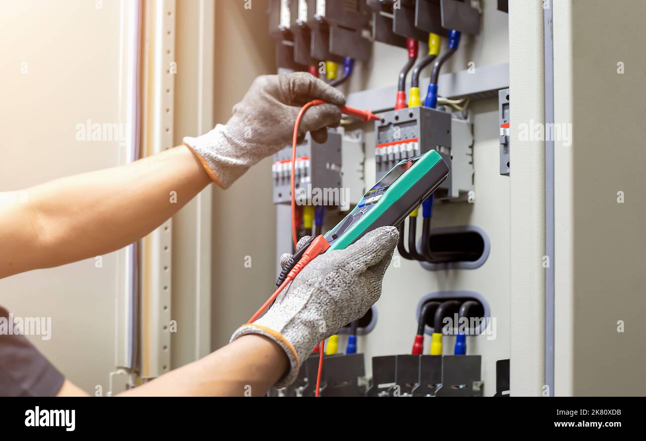 L'ingénieur électricien teste régulièrement le fonctionnement de l'armoire de commande électrique pour la maintenance. Banque D'Images