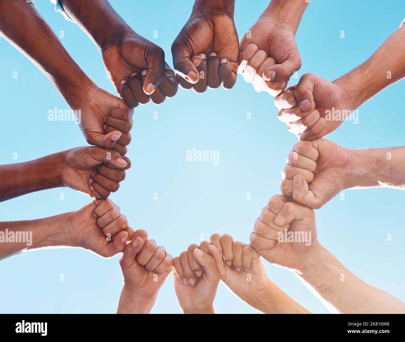 Les mains de poing, le cercle et la diversité soutiennent les droits de l'homme, les groupes de protestation et la liberté du racisme sur fond bleu ciel. Au-dessous de la solidarité Banque D'Images
