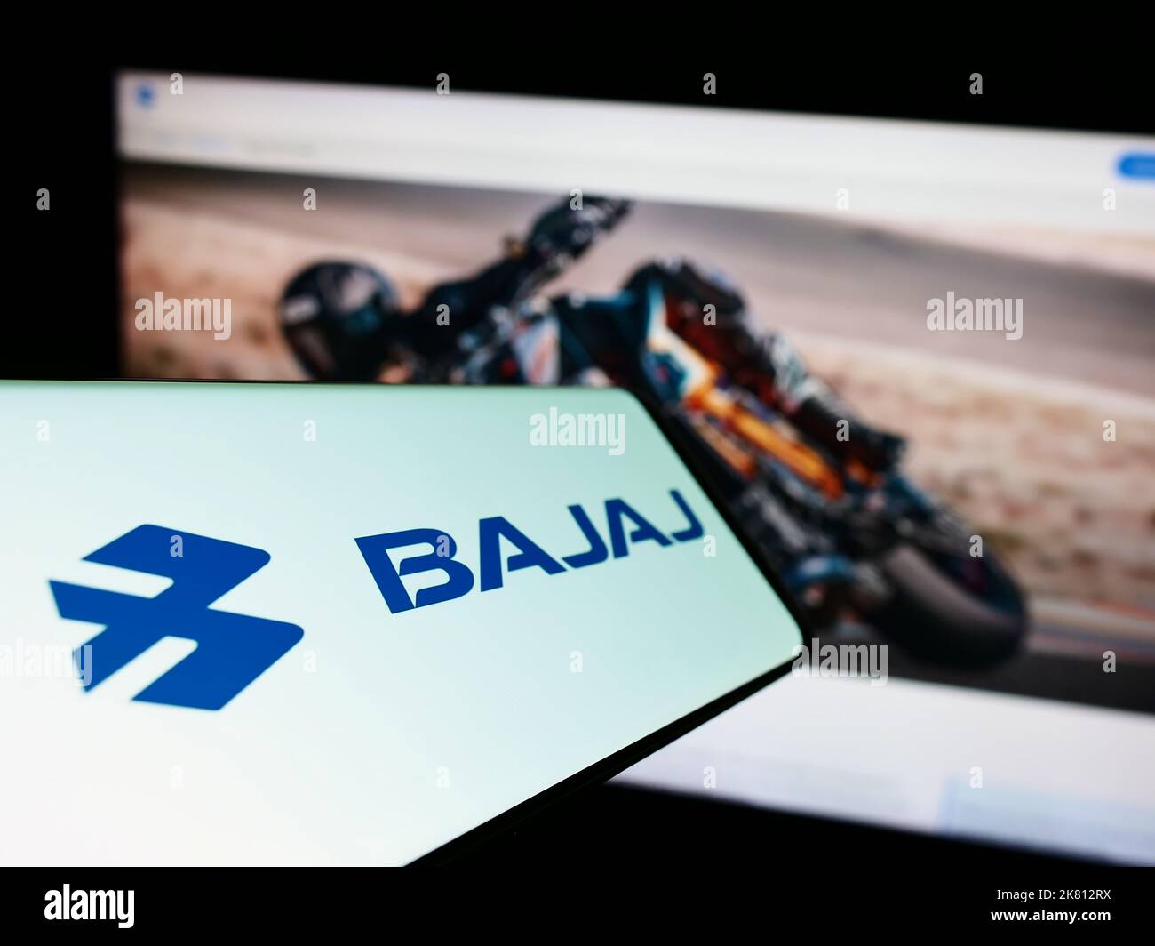 Téléphone mobile avec logo de la société automobile indienne Bajaj Auto Limited à l'écran devant le site Web. Mise au point au centre-gauche de l'écran du téléphone. Banque D'Images