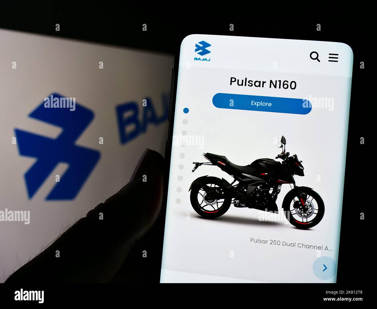 Personne tenant un téléphone portable avec la page web de la compagnie automobile indienne Bajaj Auto Limited à l'écran avec logo. Concentrez-vous sur le centre de l'écran du téléphone. Banque D'Images