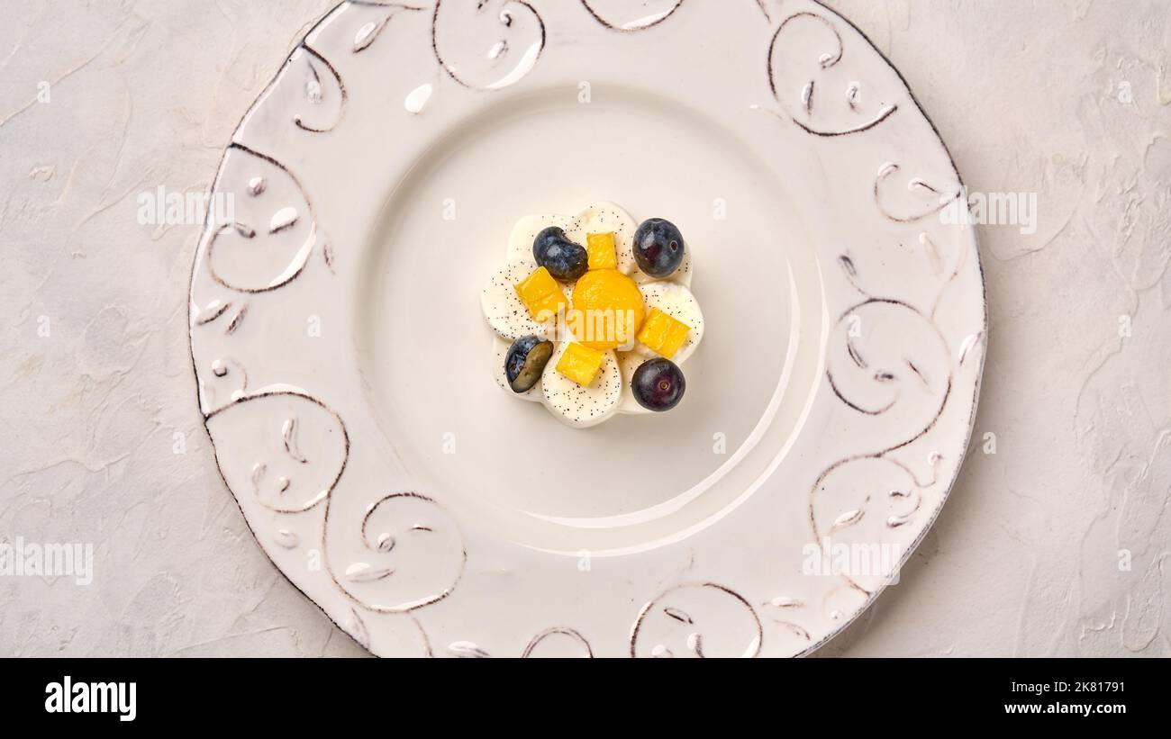 Vue de dessus Panna cotta maison avec gousse de vanille naturelle, mangue et raisin, clé haute Banque D'Images