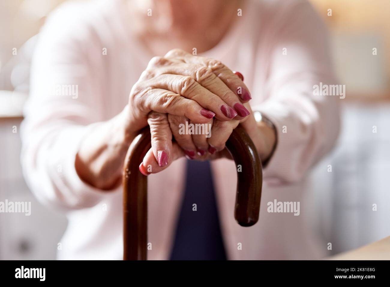 Une vision déformée m'a transformé en compromis. Gros plan d'une femme âgée méconnue qui tient dans une canne à la maison. Banque D'Images