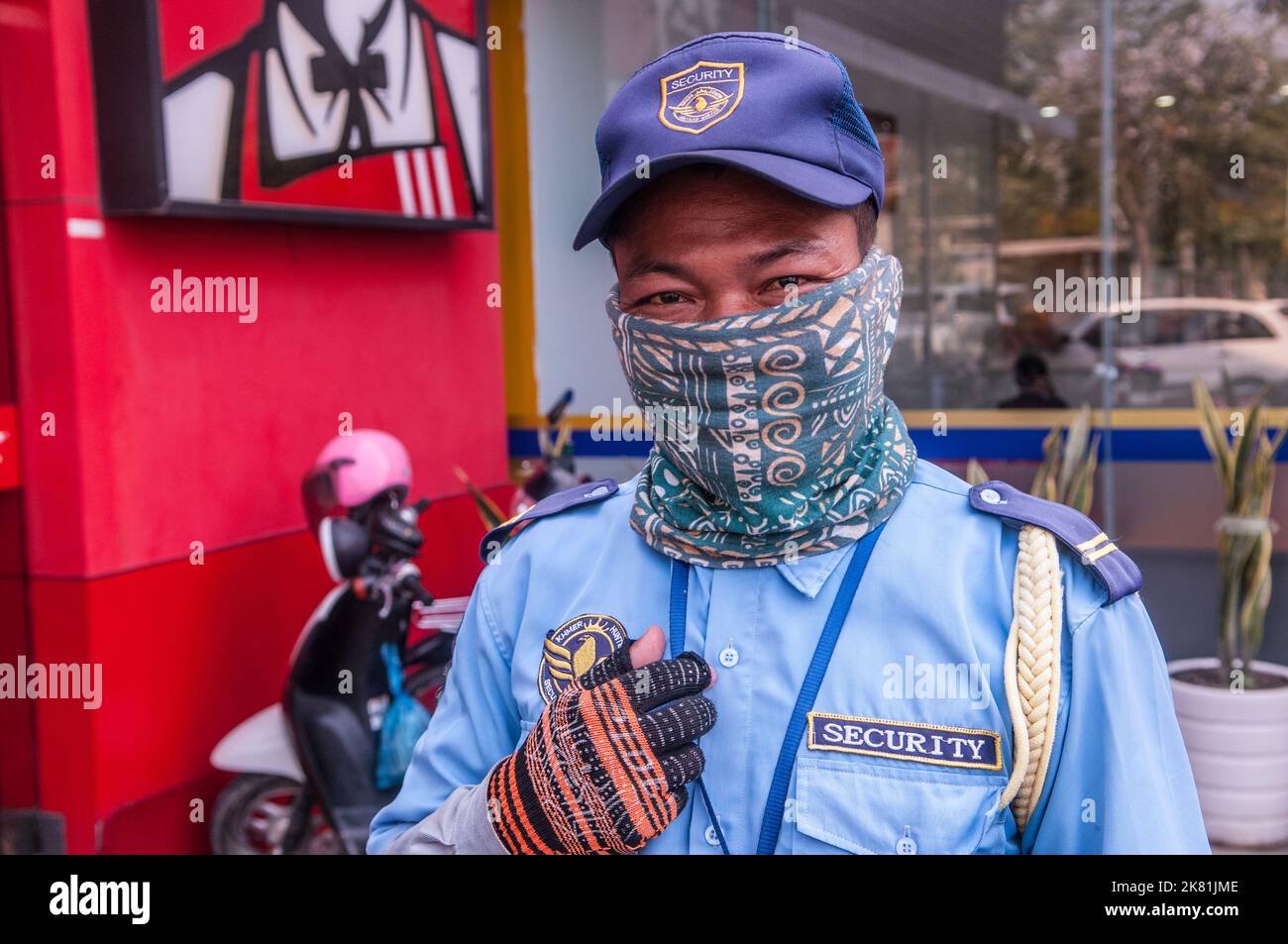 Lors d'une épidémie de COVID - 19, un agent de sécurité d'un KFC porte un masque élégant. Phnom Penh, Cambodge. 15 mars 2021. © Kraig Lieb Banque D'Images