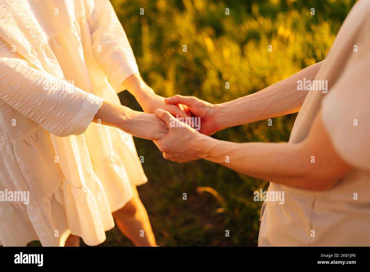 Gros plan court de jeunes couples méconnaissables, amoureux du champ, en tenant les mains et en portant les paumes avec les doigts. Banque D'Images
