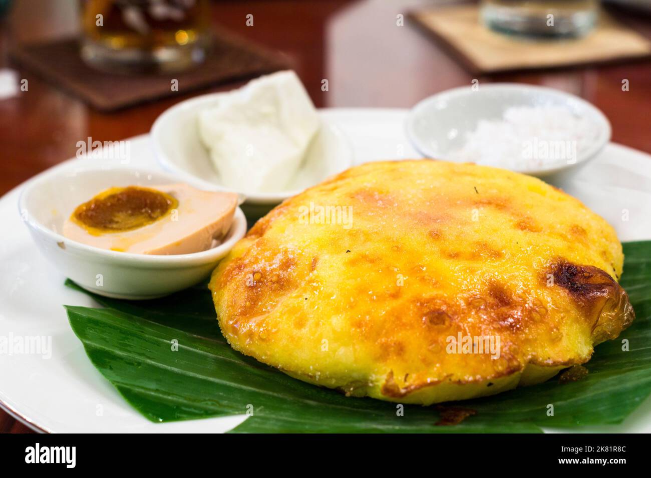 Bibingka philippin ou gâteau au riz avec des garnitures de fromage blanc, de la viande de noix de coco blanche râpée et une tranche d'œuf de canard salé à Makati City, Philippines Banque D'Images