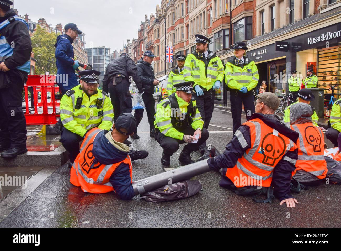 Londres, Angleterre, Royaume-Uni. 20th octobre 2022. Les activistes Just Stop Oil ont collé leurs mains et se sont attachés à des tuyaux métalliques sur Brompton Road à l'extérieur de Harrods, et ont pulvérisé de la peinture orange sur les fenêtres du célèbre grand magasin de Knightsbridge, alors qu'ils poursuivent leurs protestations exigeant que le gouvernement cesse d'émettre de nouvelles licences de combustibles fossiles. (Image de crédit : © Vuk Valcic/ZUMA Press Wire) Banque D'Images