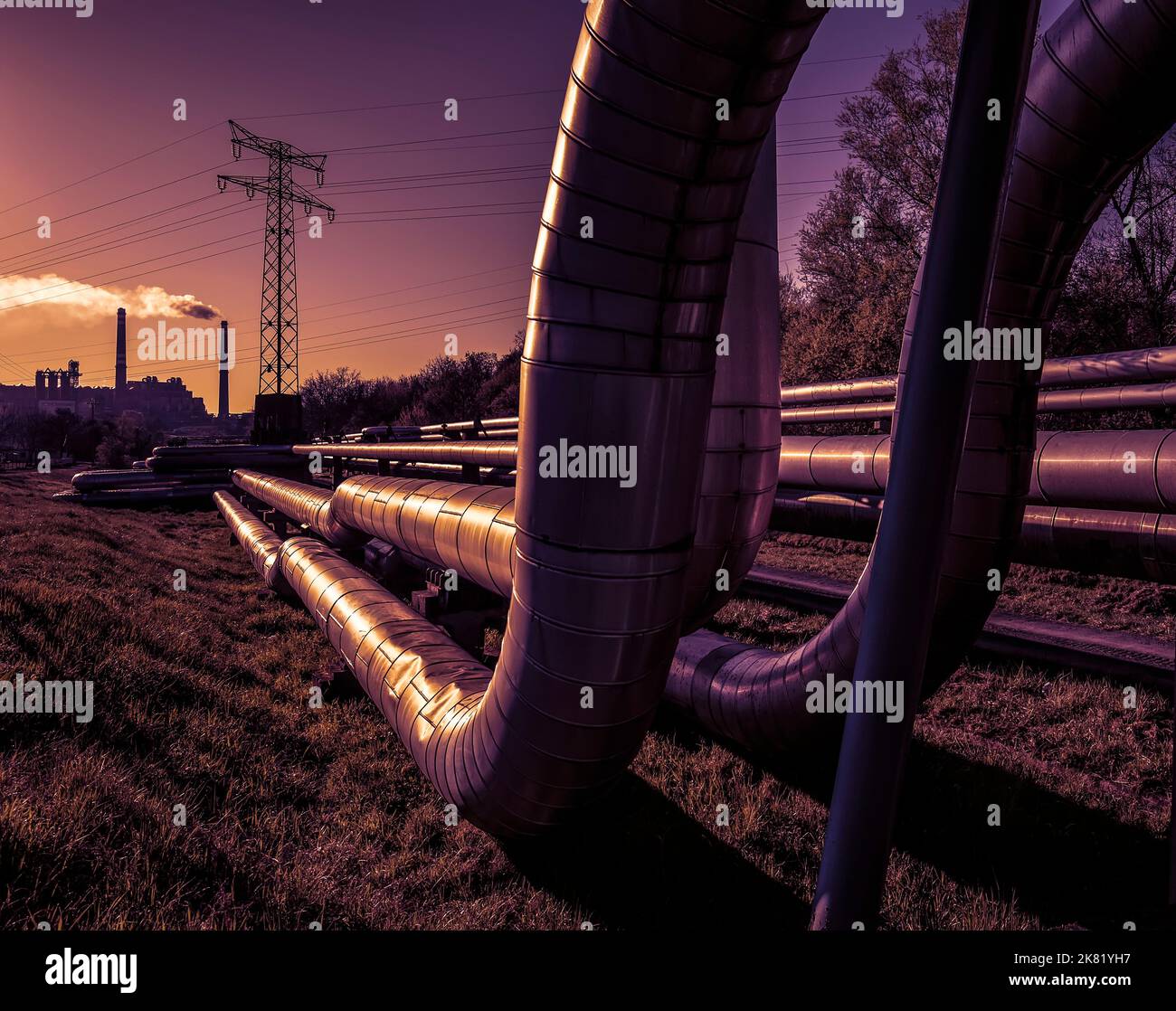 Fils électriques et tubes de chauffage urbain au lever du soleil Banque D'Images