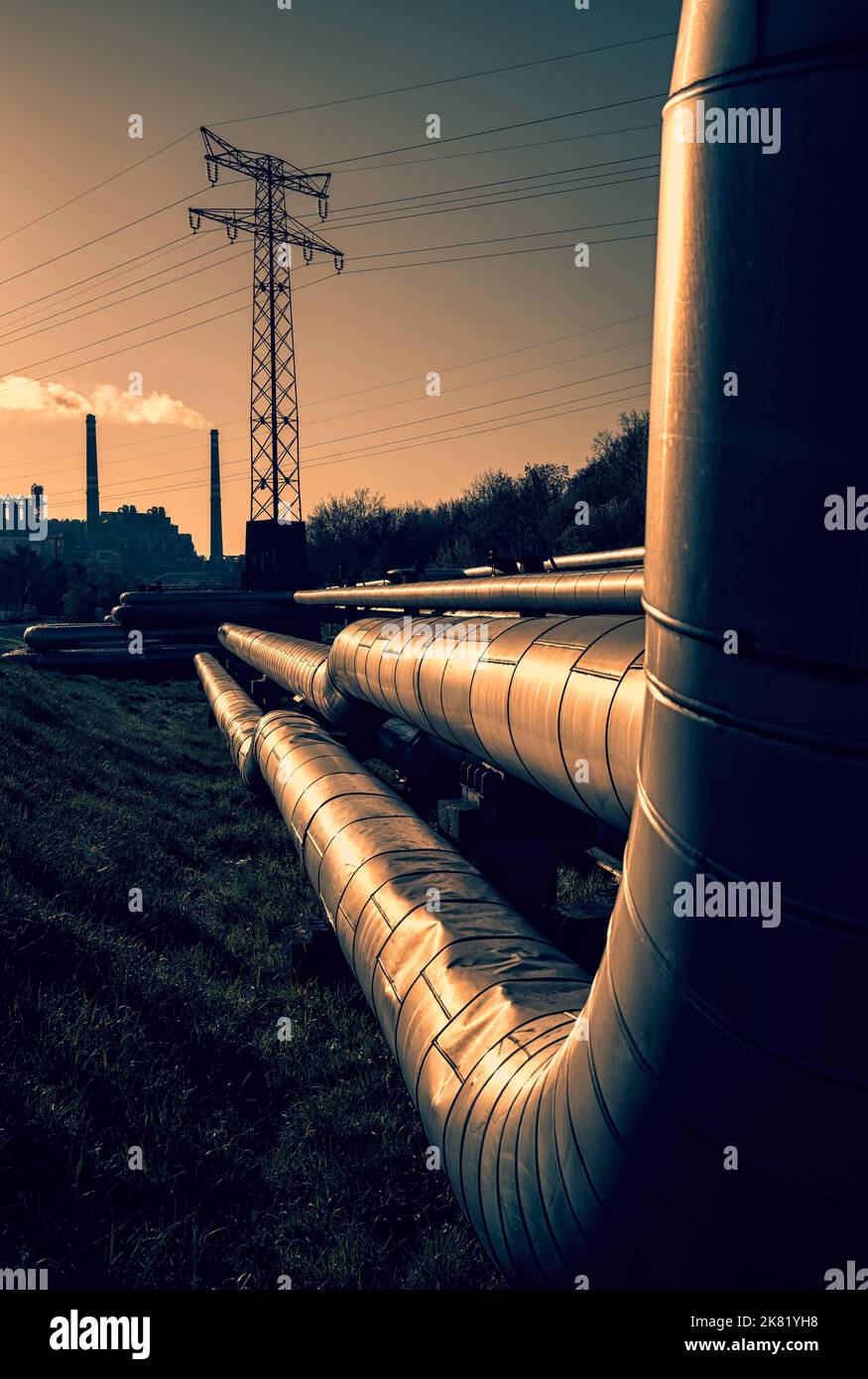 Fils électriques et tubes de chauffage urbain au lever du soleil Banque D'Images