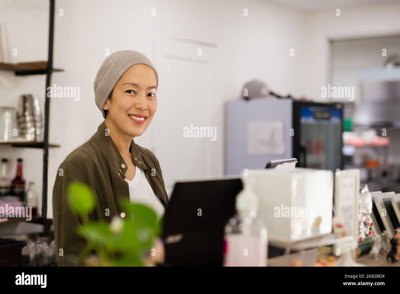 Femme propriétaire du restaurant debout au comptoir recevant les commandes. Banque D'Images