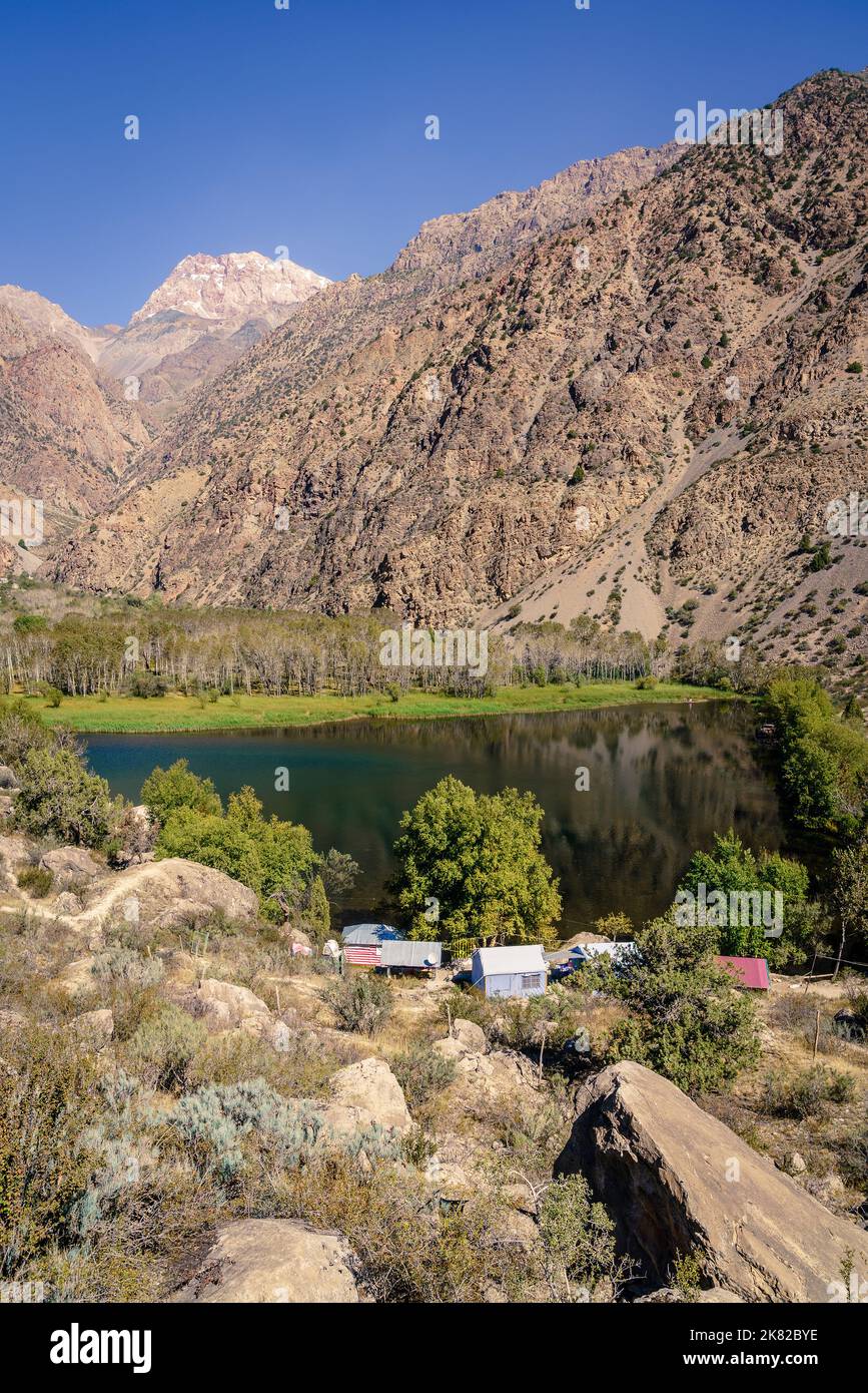 Vue panoramique sur les montagnes, le petit lac et un camp touristique au Tadjikistan Banque D'Images