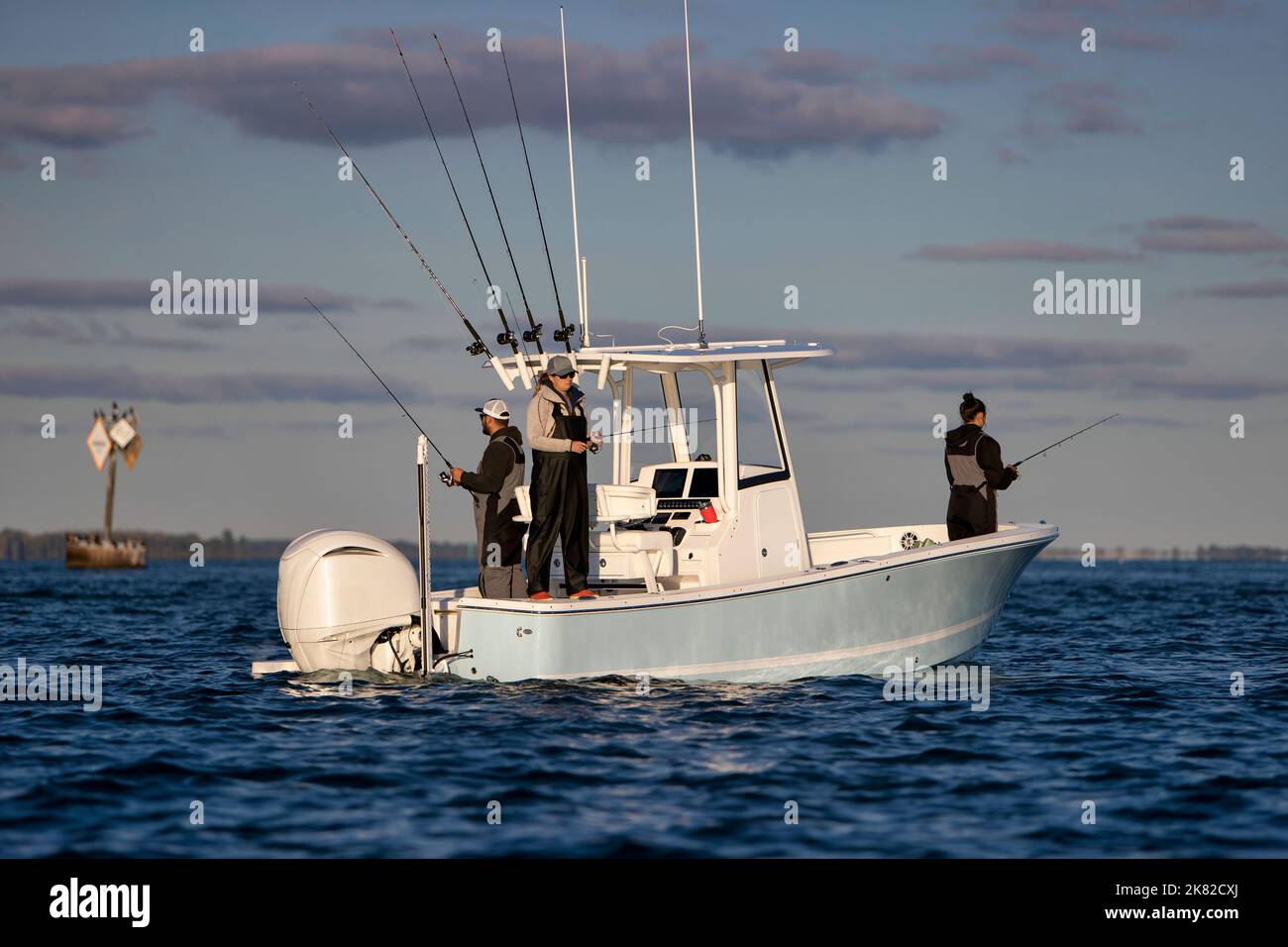Trois personnes debout dans un bateau et la pêche. Banque D'Images