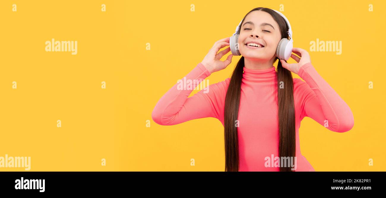 formation en ligne. séminaire en ligne. rentrée scolaire. enfant écoutez de la musique dans un casque. Portrait d'enfant avec casque, affiche horizontale. Fille à l'écoute Banque D'Images