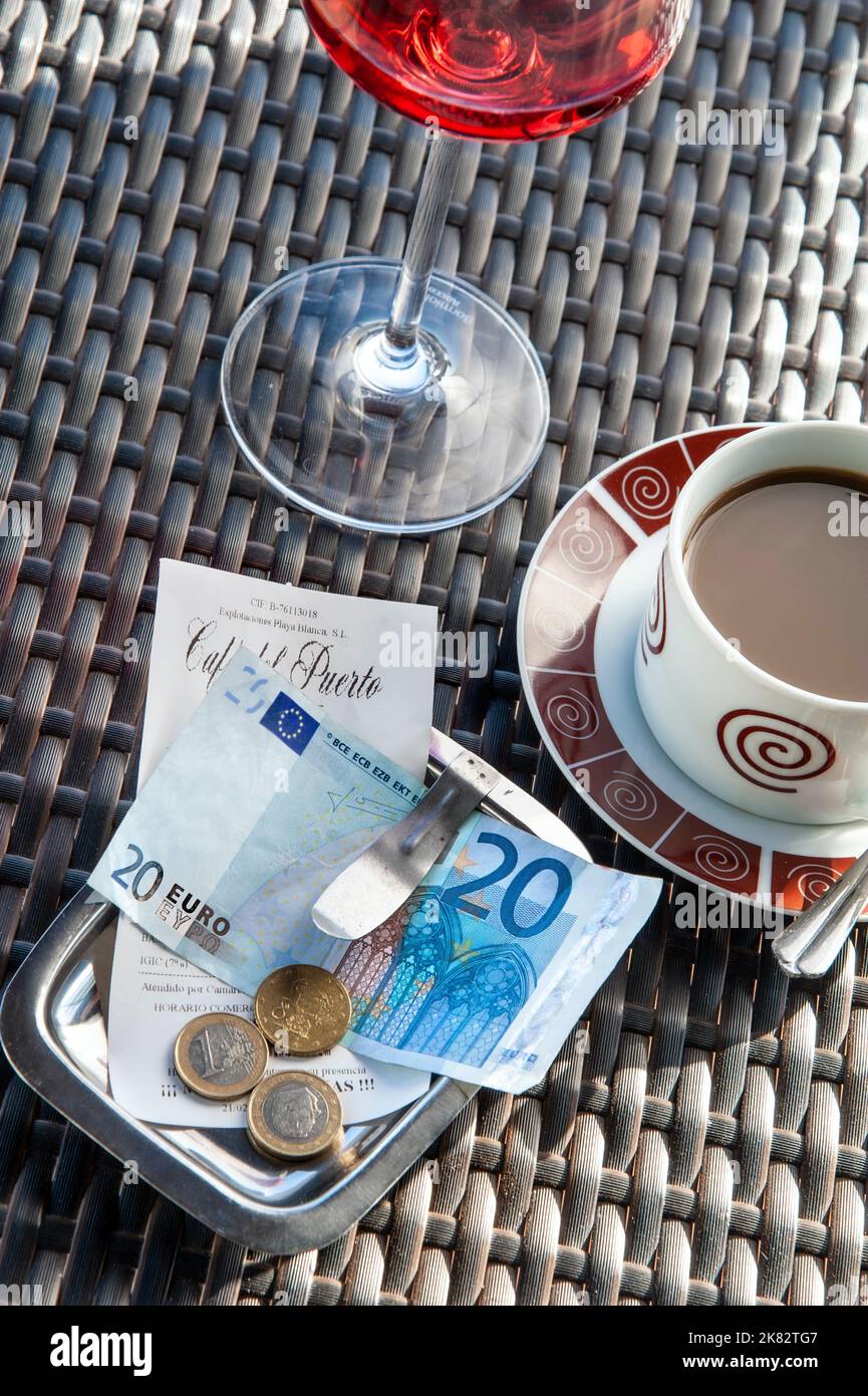 EURO facture restaurant avec 20€ note de paiement en euros sur la table de restaurant espagnol ensoleillée en plein air avec un verre de vin rose et une tasse de café Banque D'Images