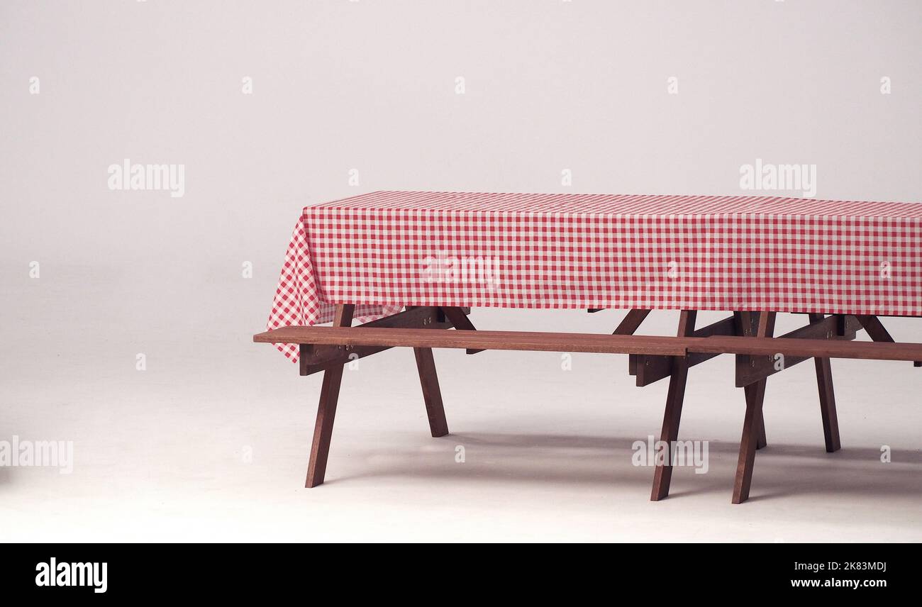 Table en bois et serviette rouge pour les fêtes en plein air et fond blanc. Banque D'Images