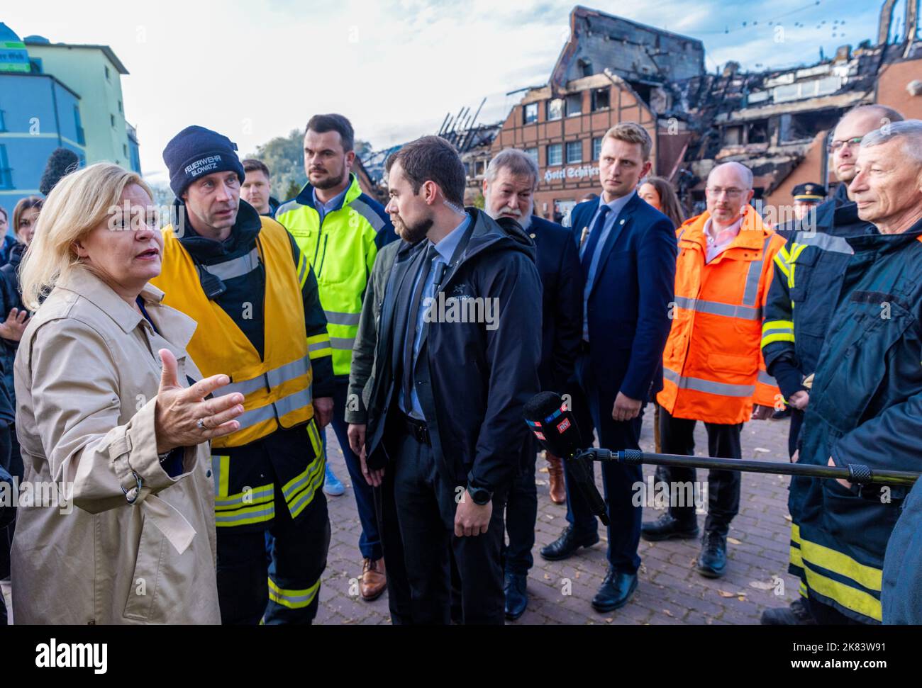 Allemagne. 20th octobre 2022. 20 octobre 2022, Mecklembourg-Poméranie occidentale, Groß Strömkendorf: Nancy Faeser (l, SPD), ministre fédérale de l'intérieur, parle devant l'hôtel brûlé avec des pompiers qui ont été impliqués dans les travaux de sauvetage. Le bâtiment, qui abritait des réfugiés d'Ukraine, a brûlé la nuit dernière. Personne n'a été blessé dans l'incendie, on soupçonne un incendie criminel. Les 14 résidents ont été logés dans d'autres appartements après les travaux de sauvetage. Photo: Jens Büttner/dpa crédit: dpa Picture Alliance/Alay Live News Banque D'Images