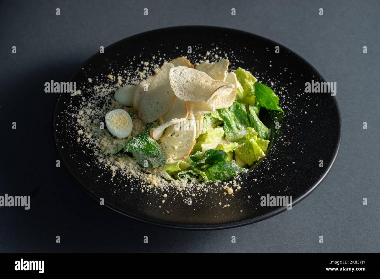 salade césar claire sans viande sur plaque noire sur fond sombre Banque D'Images