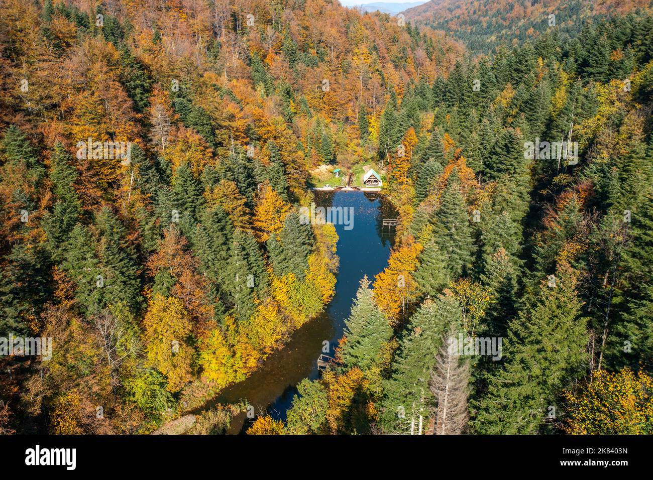 Magnifique paysage pittoresque avec lac et pavillon de pique-nique à côté de lui entouré d'arbres colorés en automne Banque D'Images