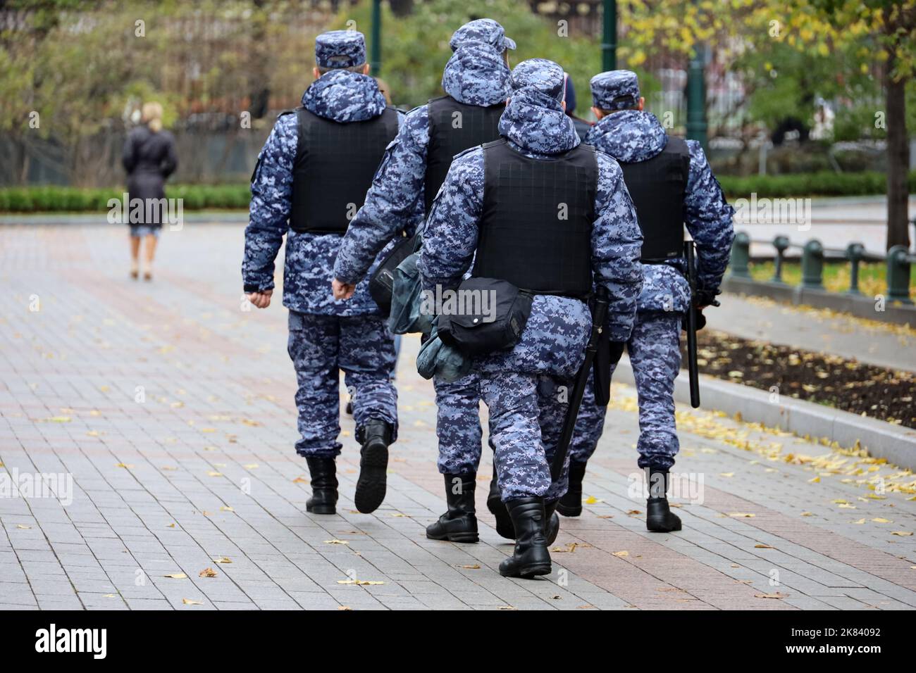 Des soldats des forces militaires russes en camouflage et à l'épreuve des balles se promparent dans la rue de la ville en automne Banque D'Images