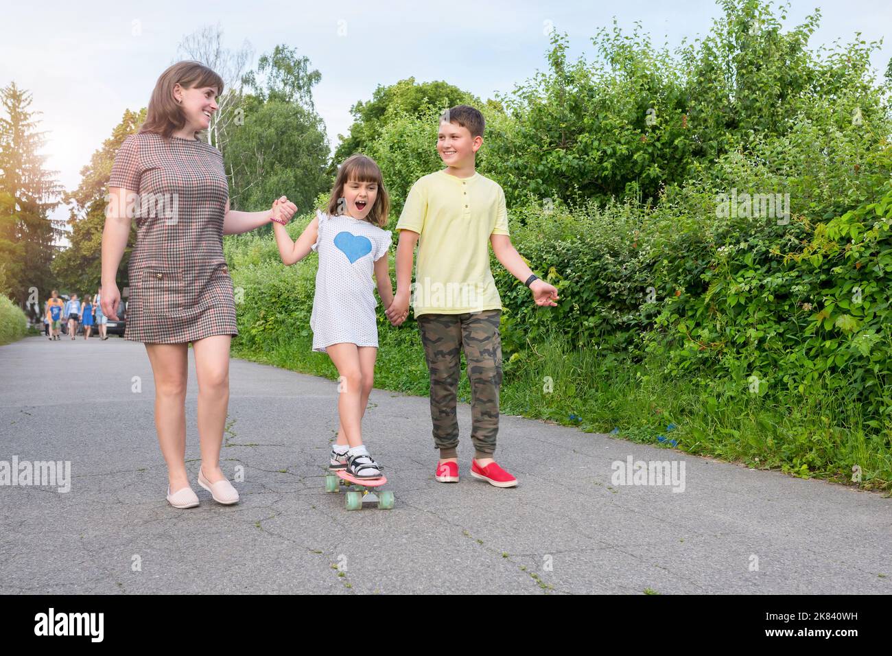 Femme avec enfants pour une promenade dans le parc. Bonne famille Banque D'Images