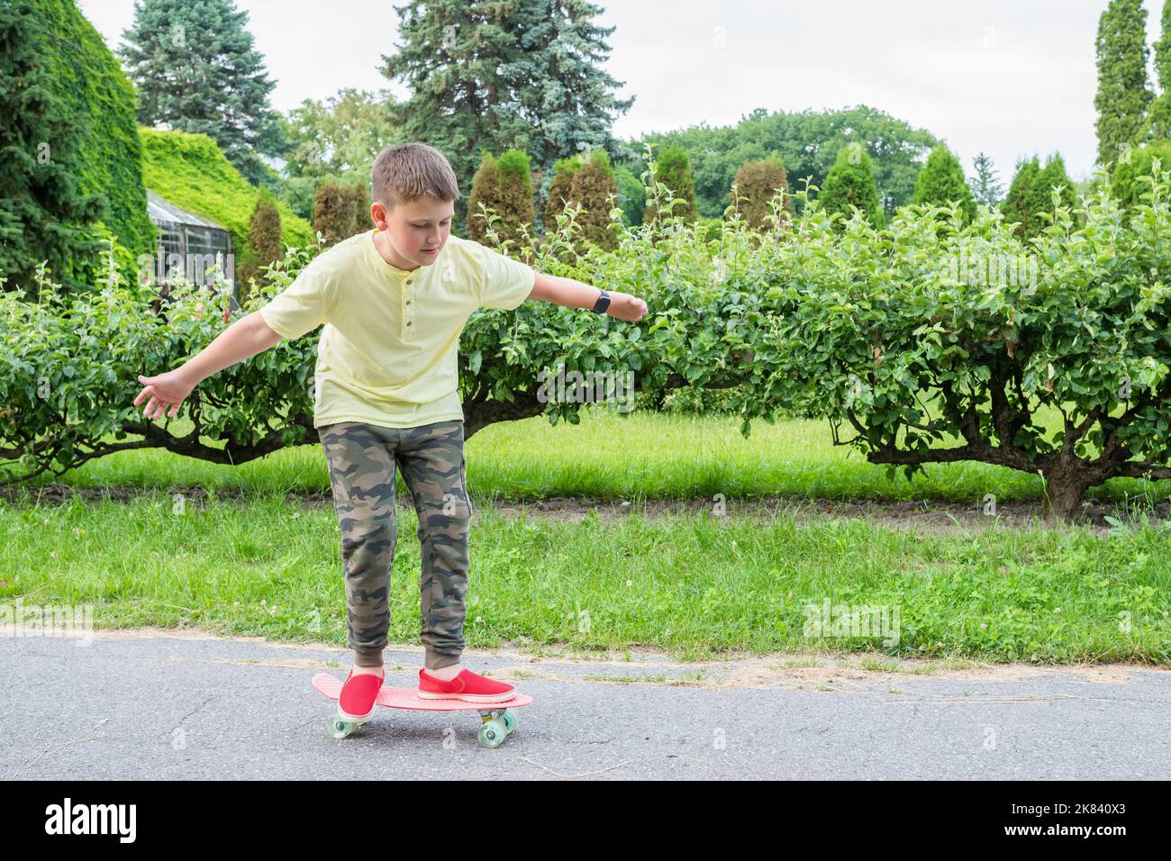 Le skateboard pour garçon dans le parc. L'enfant entre pour le sport Banque D'Images