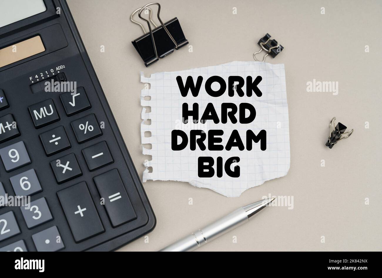 Concept commercial et financier. Sur la table se trouve une calculatrice, un stylo et du papier avec l'inscription - Work Hard Dream Big Banque D'Images