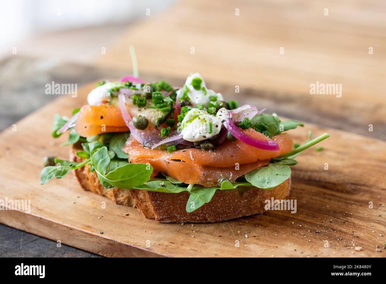 Sandwich ouvert avec saumon fumé, oignons marinés, crème sure et câpres Banque D'Images