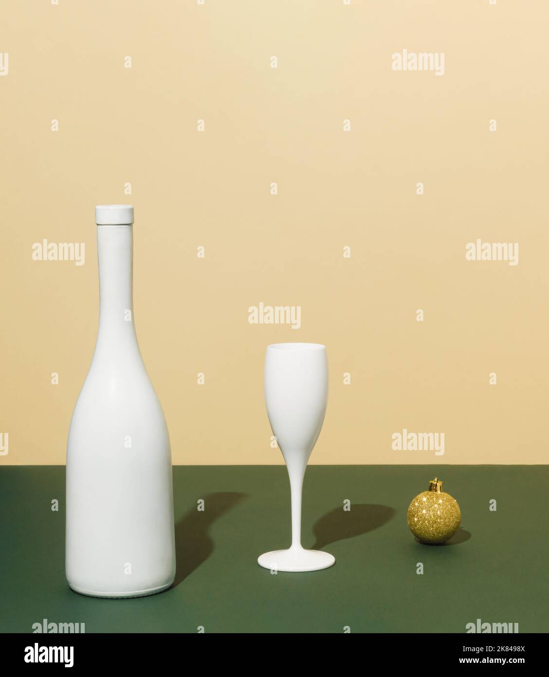 Bouteille de champagne blanc, boule de Noël et verre. Concept de fête minimal. Idée de célébration du nouvel an et de Noël. Banque D'Images