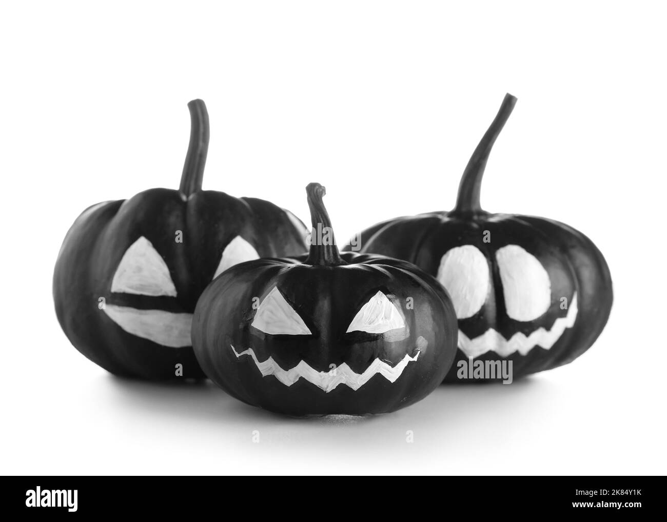 Citrouilles d'Halloween noires avec visage dessiné sur fond blanc Banque D'Images