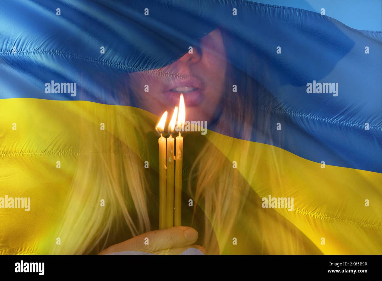 Drapeau de l'Ukraine et visage d'une fille priante à la bougie, prière pour la paix en Ukraine, en Ukraine et dans le monde Banque D'Images