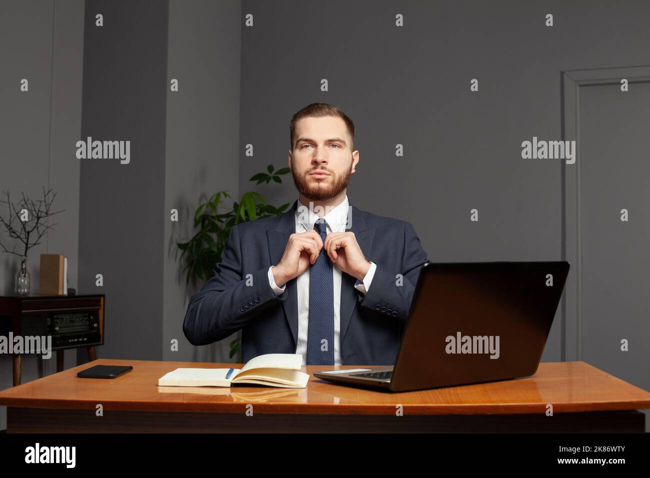 Homme d'affaires confiant et prospère travaillant sur un ordinateur portable au bureau. Concept multitâche Banque D'Images