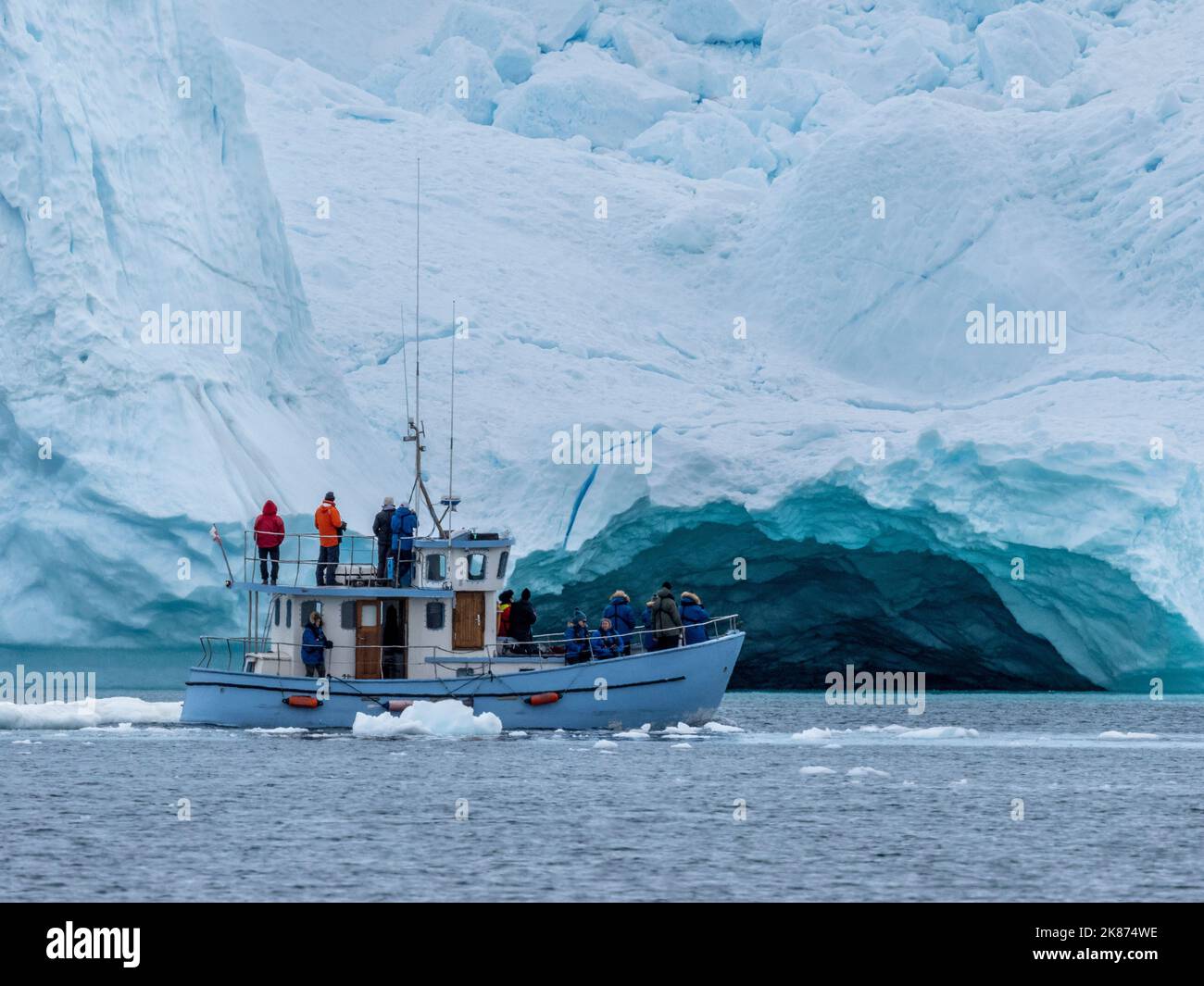 Touristes prenant une excursion sur glace dans un petit bateau observant les icebergs du Ilulissat Icefjord, juste à l'extérieur d'Ilulissat, Groenland, Danemark, régions polaires Banque D'Images