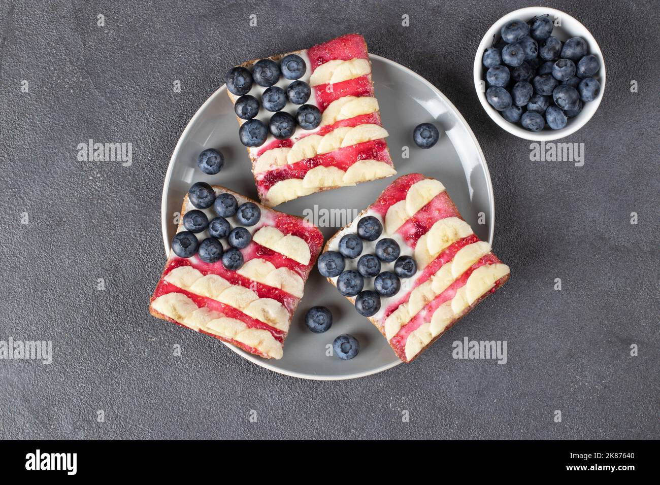 Sandwichs drapeau américain avec confiture de bleuets, de bananes et de baies sur pain grillé sur plaque grise. Vue de dessus Banque D'Images
