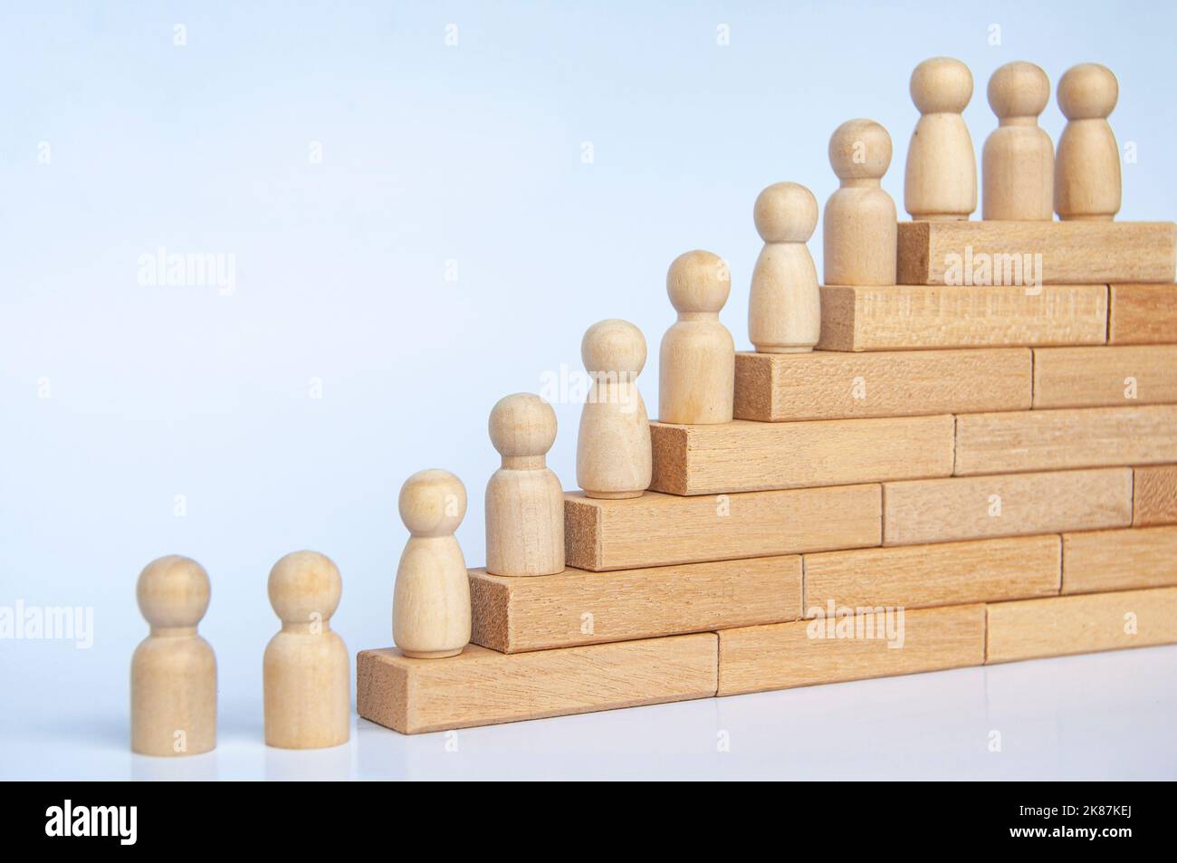 Les personnes en bois se font une figure sur des blocs de bois. Réalisation des objectifs, croissance de l'entreprise et évolution de carrière. Banque D'Images