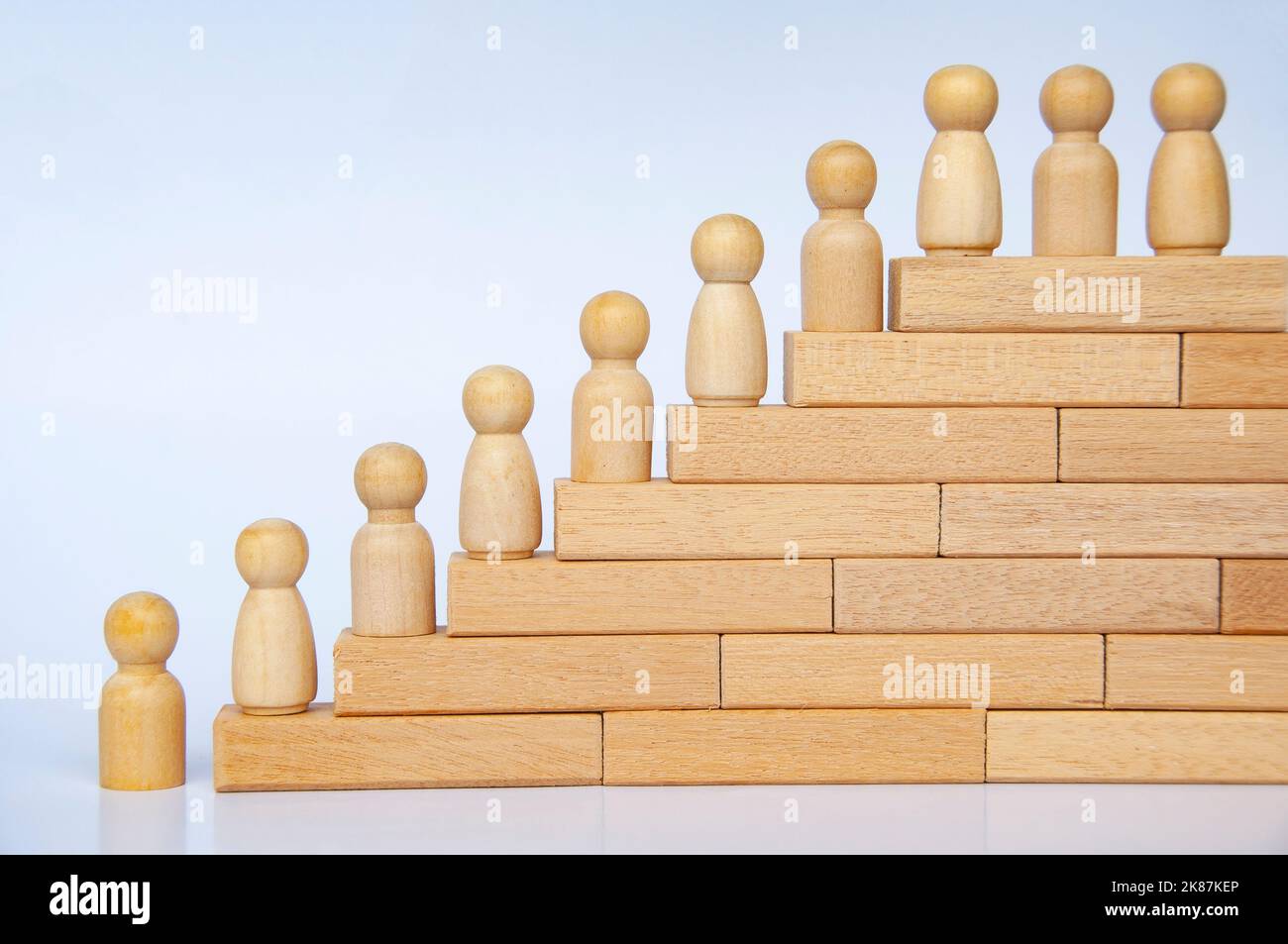 Les personnes en bois se font une figure sur des blocs de bois. Réalisation des objectifs, croissance de l'entreprise et évolution de carrière. Banque D'Images