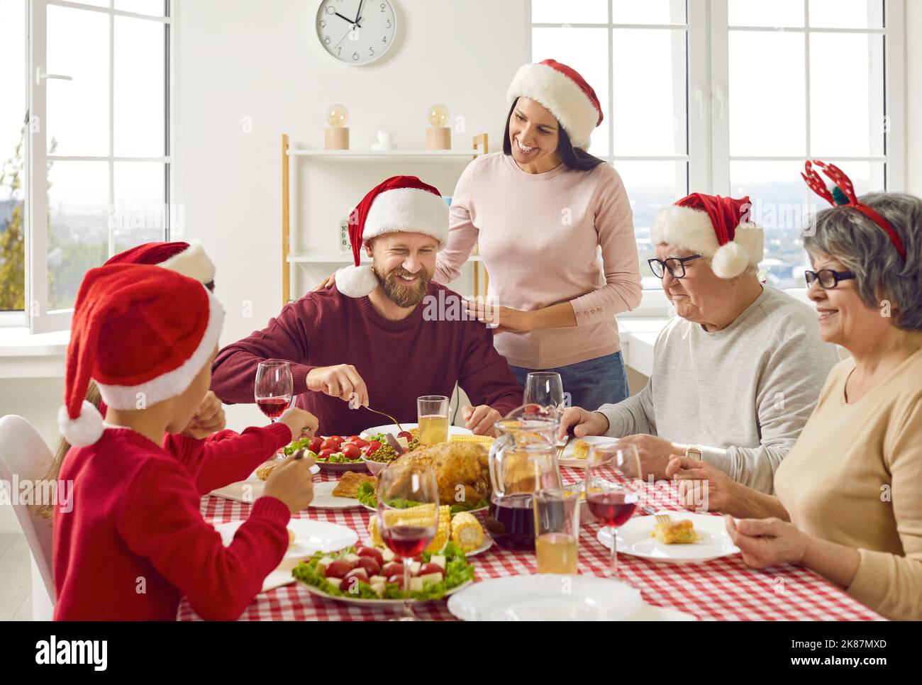 La jeune femme prend soin de sa famille pendant le repas traditionnel de Noël de petit déjeuner à la maison. Banque D'Images