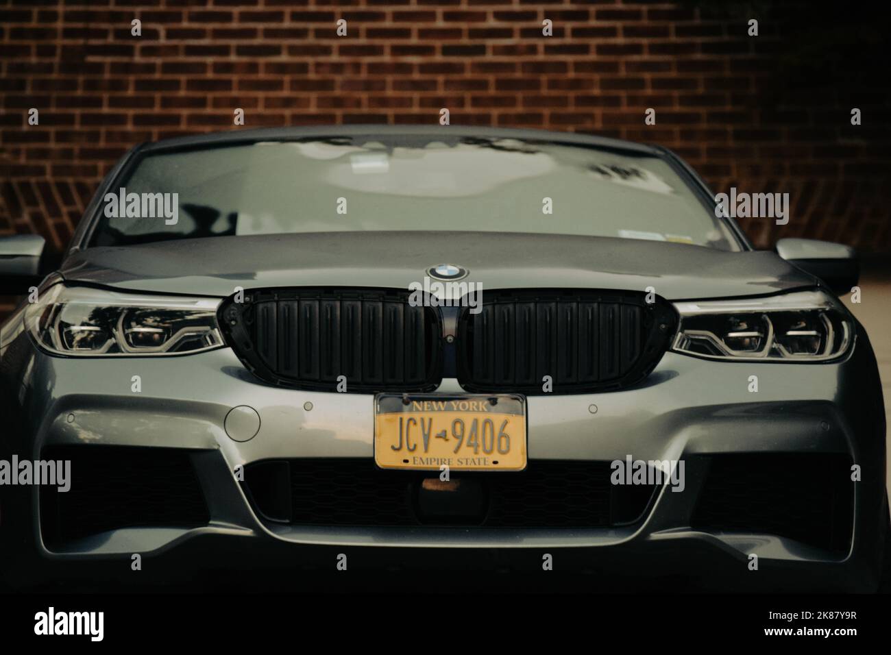 Un gros plan de la BMW 5 f90 noire garée devant le mur de briques Banque D'Images