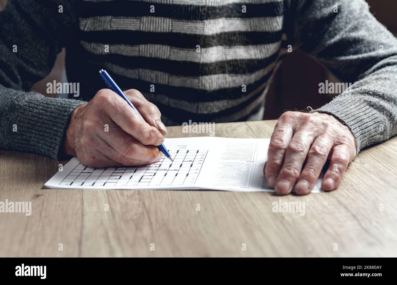Senior résout le sudoku ou un casse-mots croisés pour ralentir le progressi Banque D'Images