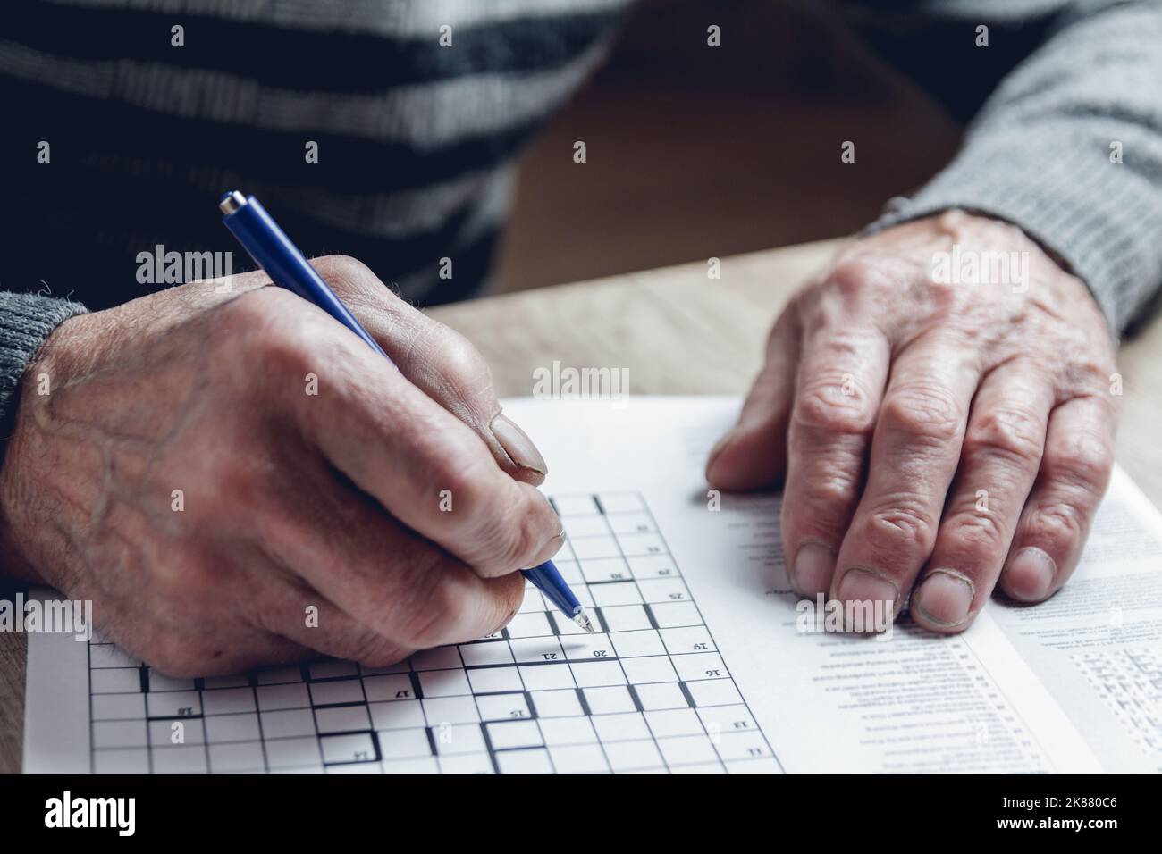Senior résout le sudoku ou un casse-mots croisés pour ralentir le progressi Banque D'Images