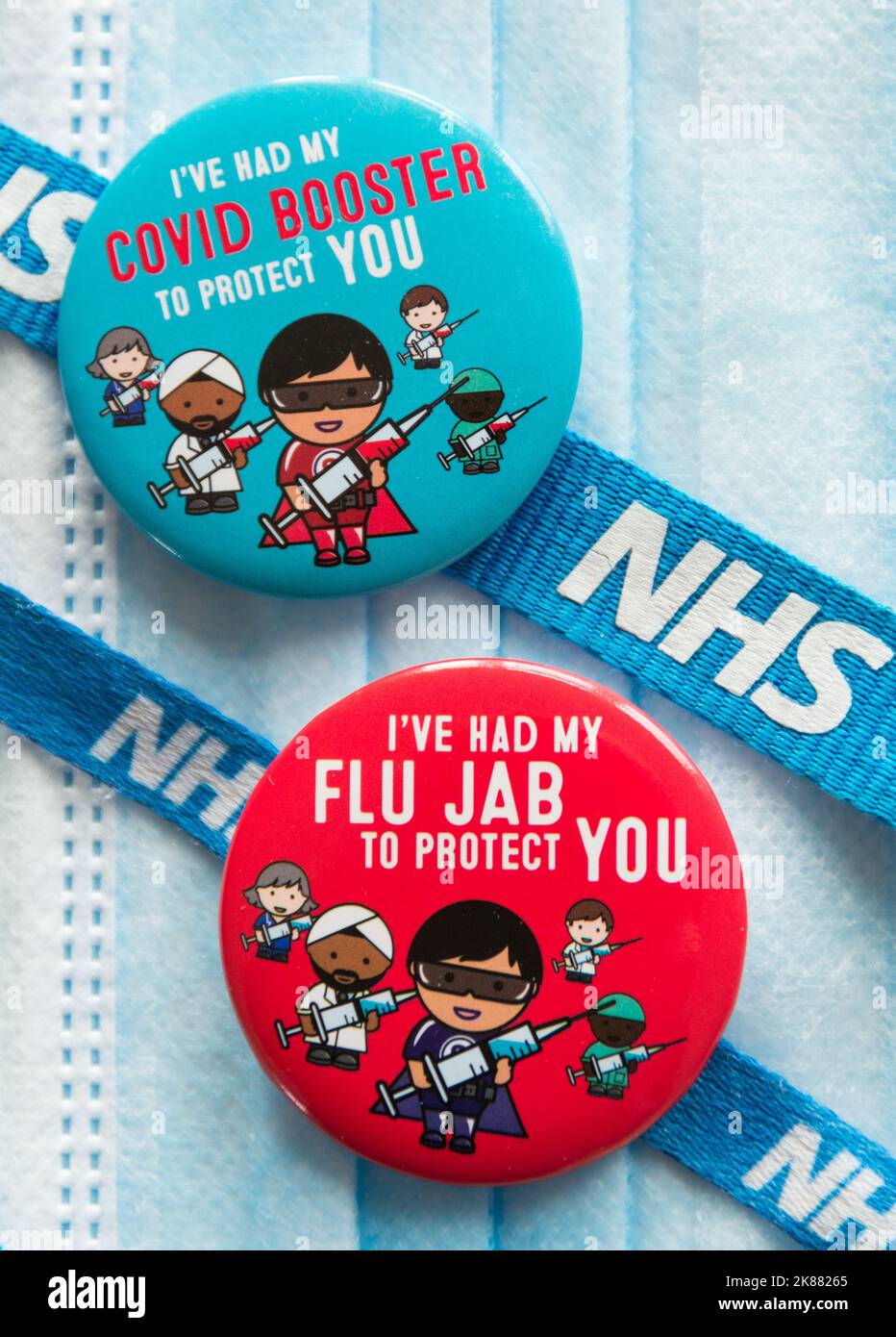 Des badges Covid 19 rehausseurs et de grippe colorés se posent sur un masque chirurgical et sont attachés à un cordon NHS Banque D'Images